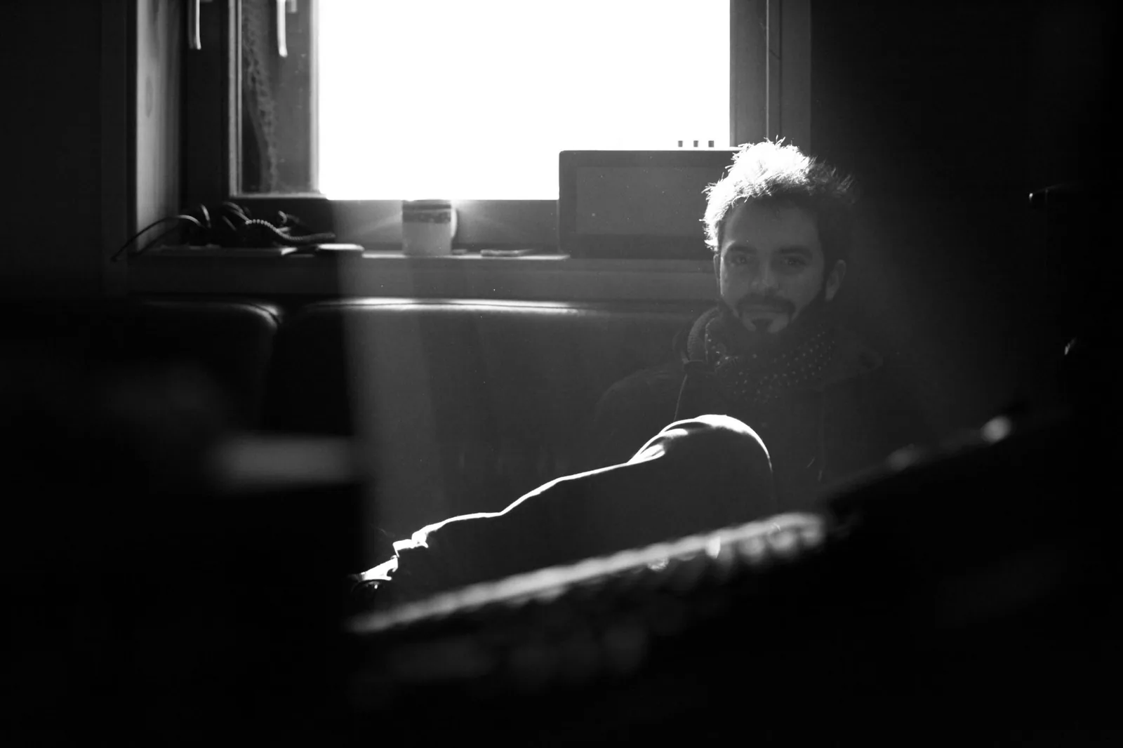 Antoine Valvin assis dans un studio, près d'une fenêtre